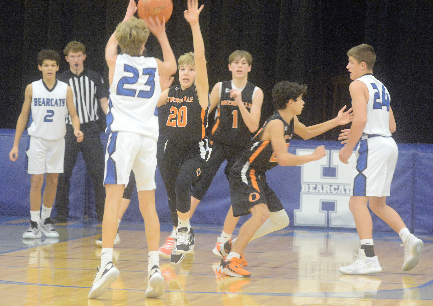 Ryker Ash (center) takes a shot for Hermann while Owensville’s Wyatt Lewis (20) gets a hand up looking to contest the shot during Monday night basketball action at Hermann Middle School.